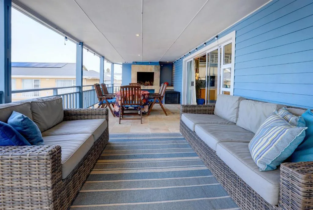 Covered deck with wicker seating, fireplace, and ocean views