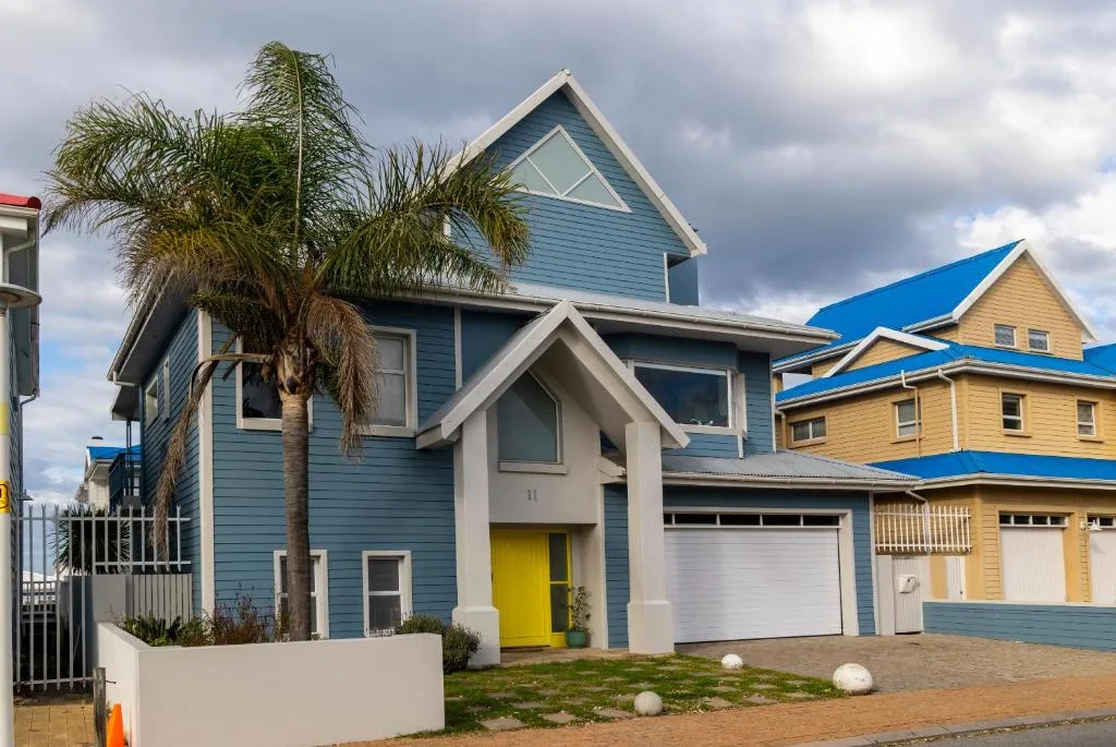 Blue and white modern house with palm tree and garage in Mossel Bay