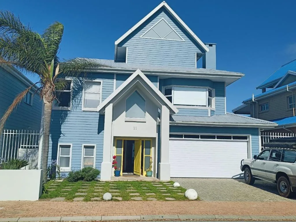 Modern blue and white two-story house with yellow door and garage