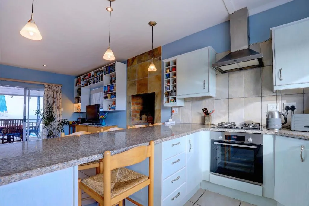 Modern kitchen with white cabinetry, granite countertop, and pendant lighting