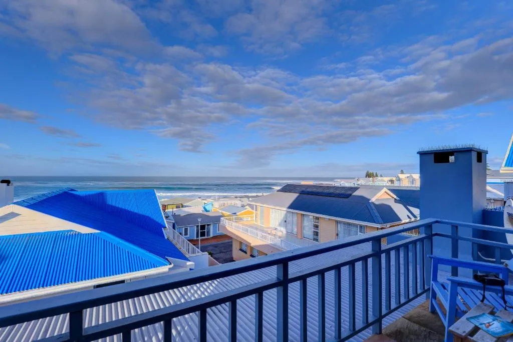 Coastal ocean view from balcony overlooking beach and colorful rooftops