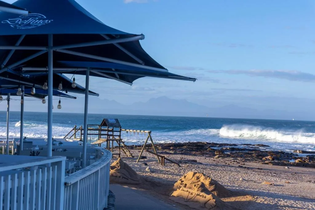 Ocean view with waves and rocky beach from shaded deck area