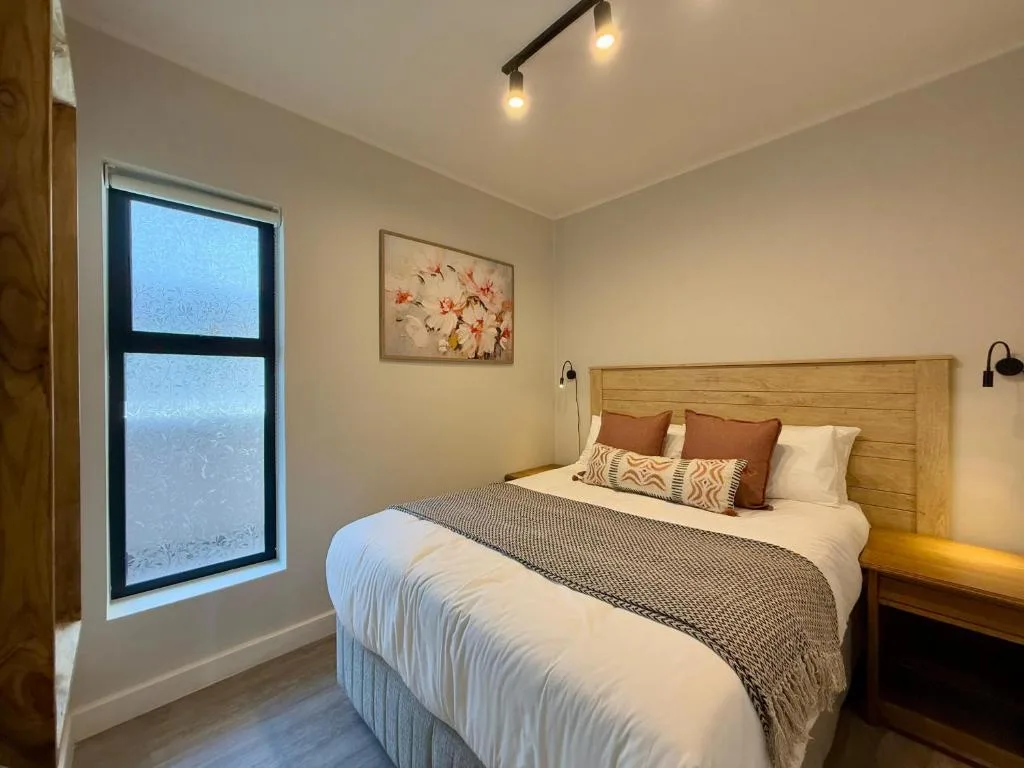 Bright bedroom with wooden headboard and warm accent lighting
