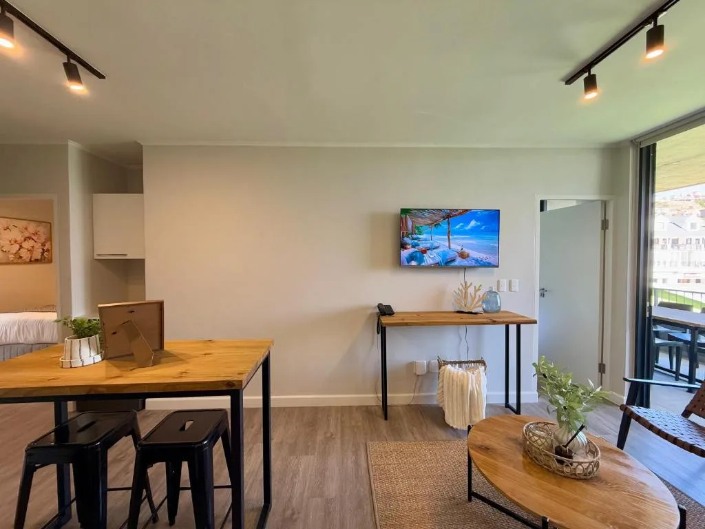Open-plan lounge and dining area with wooden tables and modern furnishings