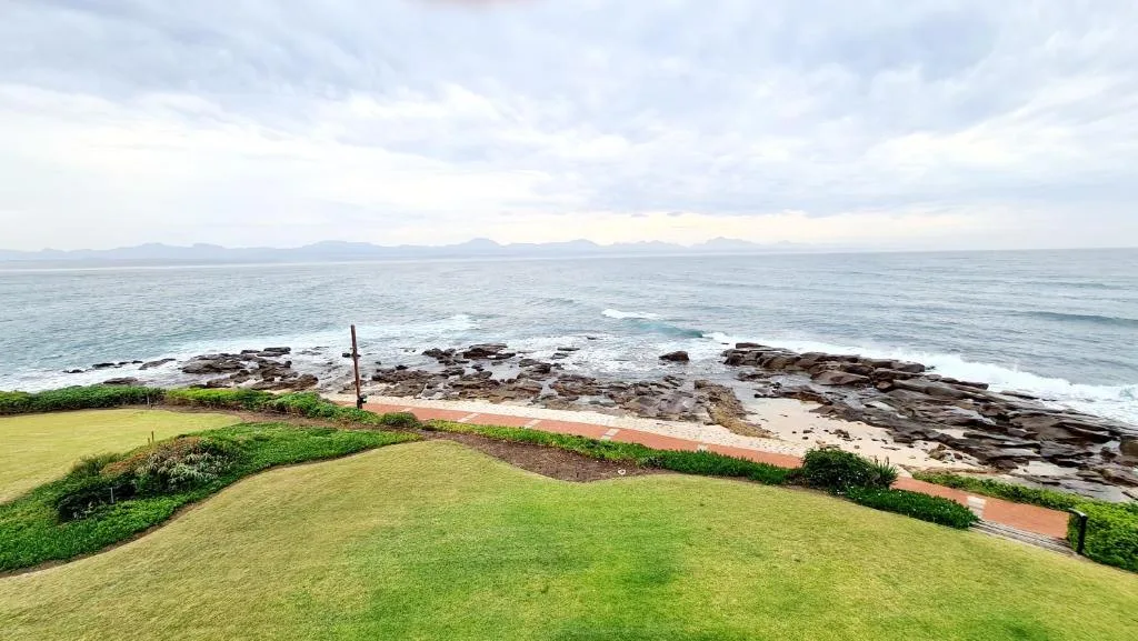 Coastal ocean view with rocky shoreline and distant mountains from property grounds