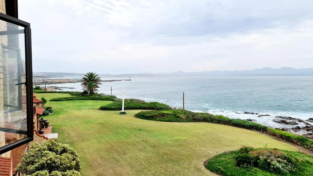 Expansive ocean and coastline vista from property overlooking green lawns