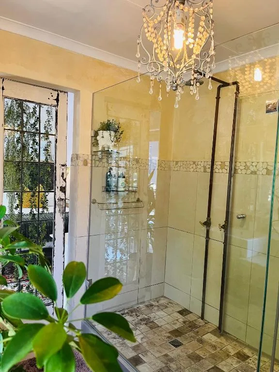 Elegant bathroom with large glass shower enclosure and soft yellow walls