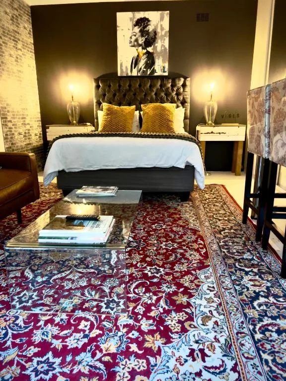 Elegantly styled bedroom with tufted headboard and golden accent pillows