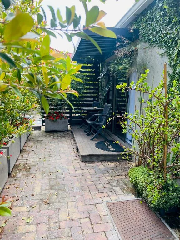 Ivy-covered patio with black lounge chairs and potted flowers