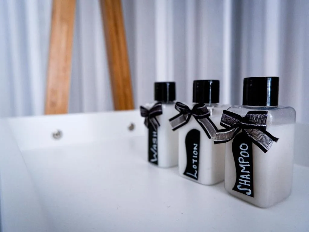 Luxury toiletries with black ribbon bows arranged on bathroom countertop