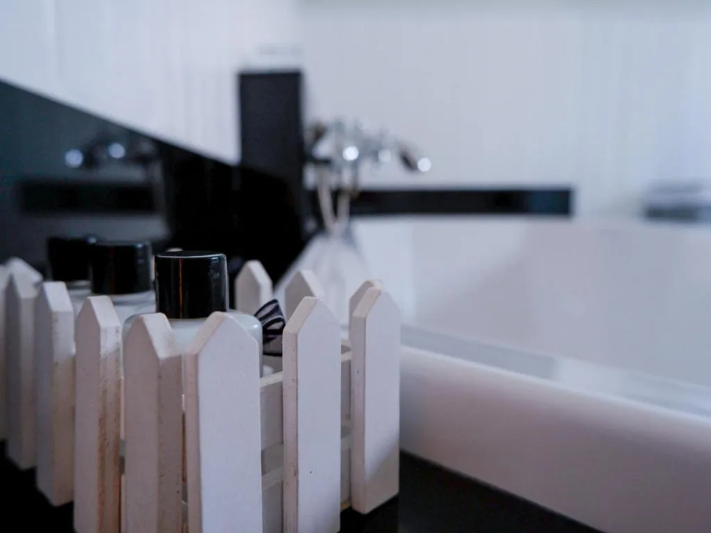Close-up of white decorative clothespins on a railing with blurred water view