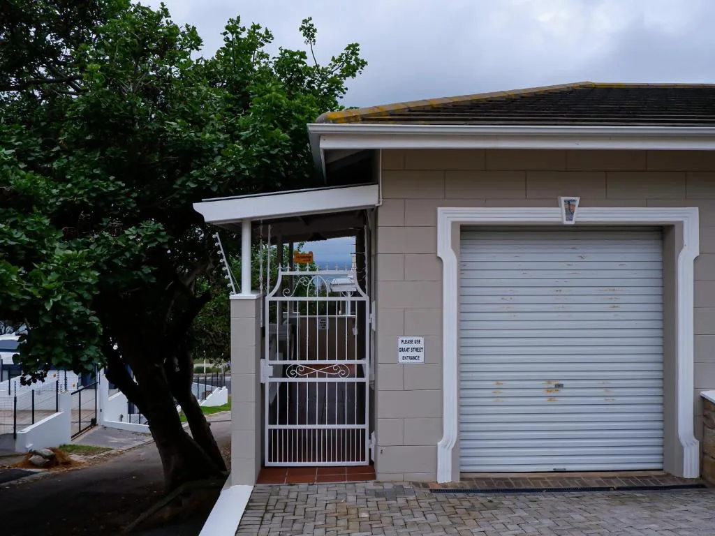 Modern beige apartment building facade with garage door and metal gate entrance