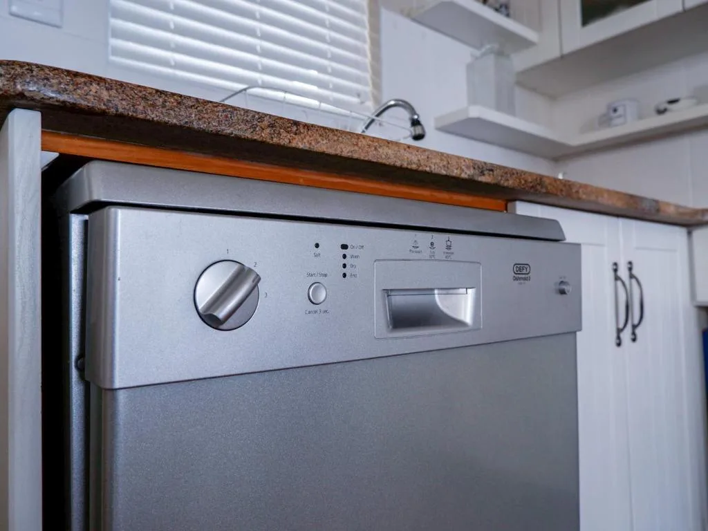 Stainless steel oven and cooktop with granite countertop in modern kitchen