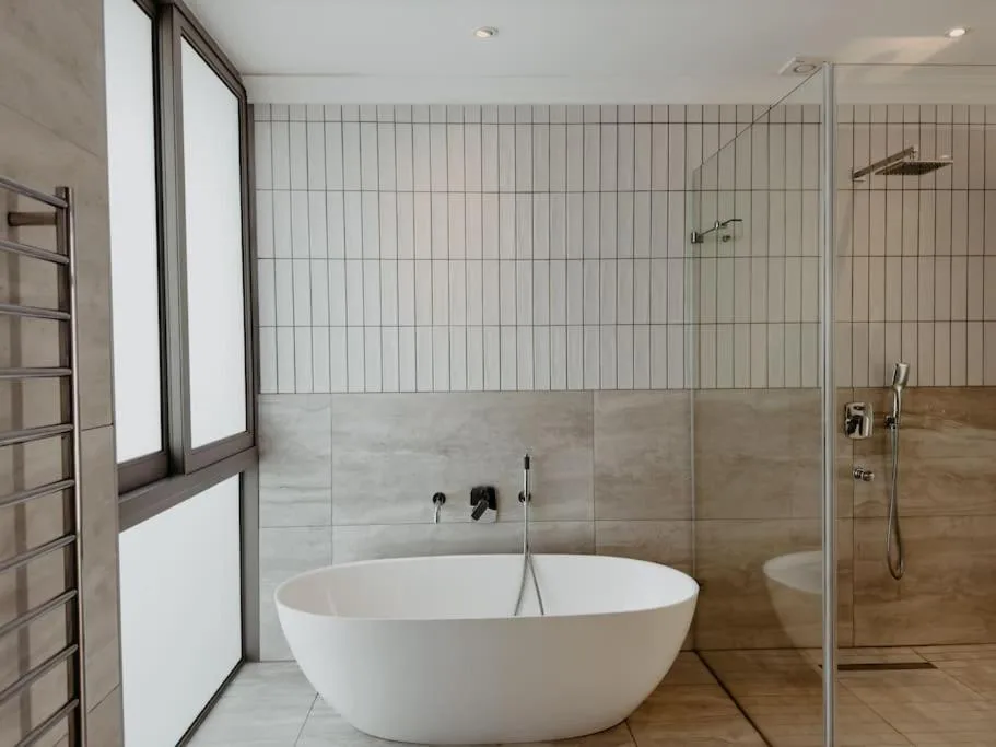 Modern bathroom with freestanding white tub and walk-in shower enclosure