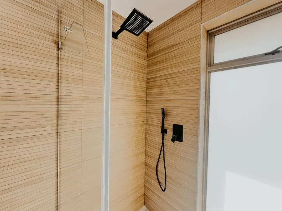Modern walk-in shower with wood-look tiles and rainfall showerhead