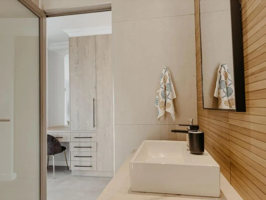 Modern bathroom with white rectangular basin and wooden wall paneling