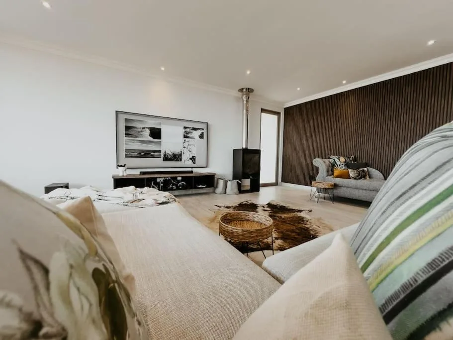 Modern bedroom with bed, TV area, and contemporary furnishings overlooking garden