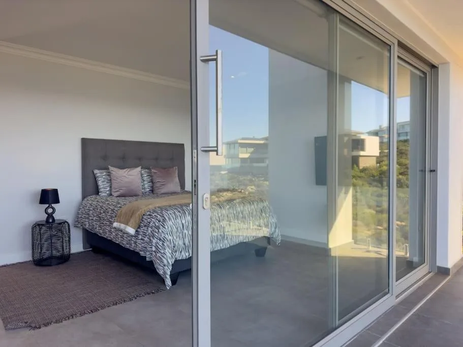 Modern bedroom with queen bed and sliding glass doors opening to patio