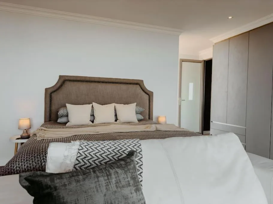Spacious bedroom with upholstered headboard bed and modern furnishings