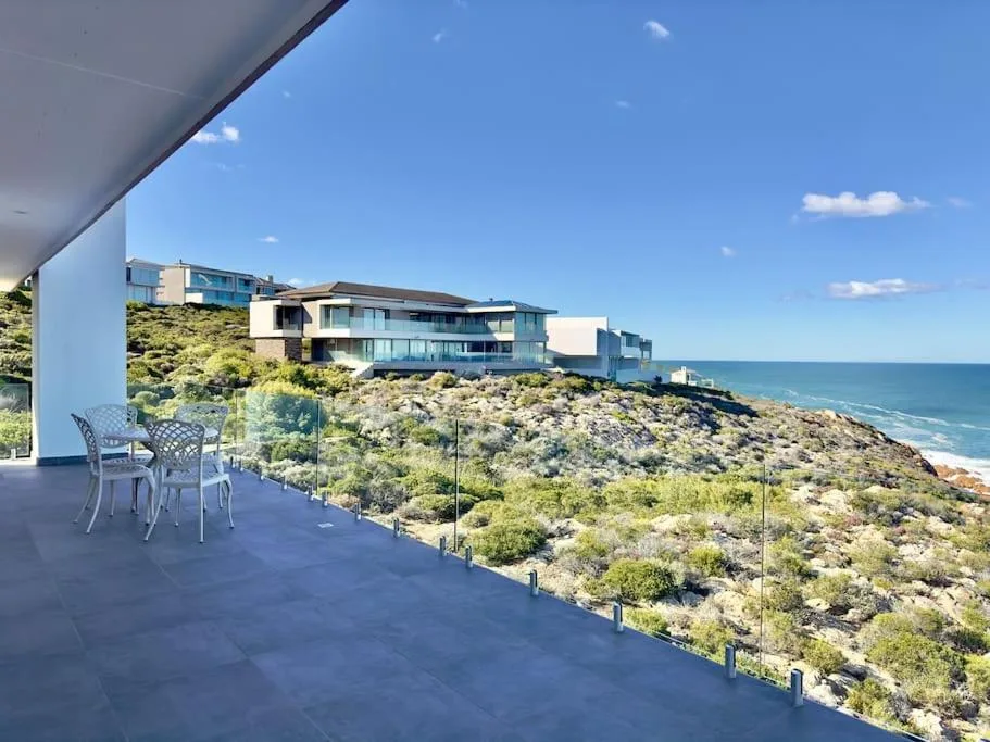 Spacious coastal deck with seating overlooking ocean and native vegetation