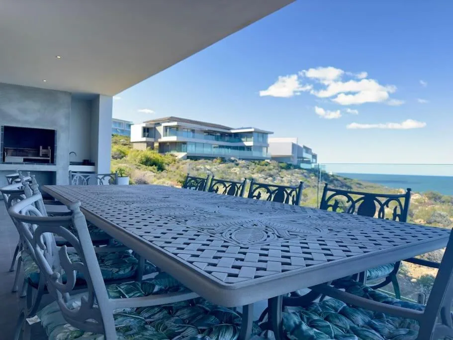 Outdoor dining table with ocean view overlooking coastal landscape and sky