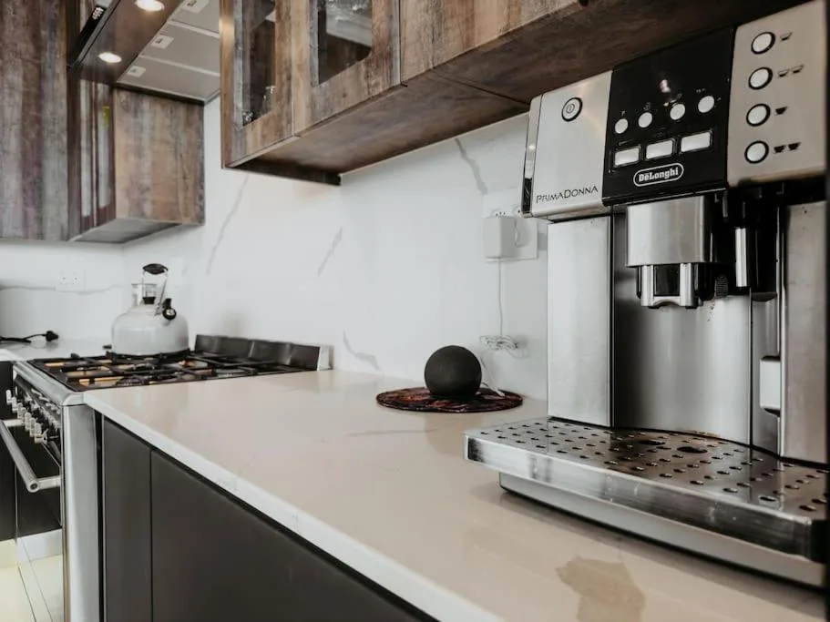 Modern kitchen with gas stove, espresso machine, and stainless steel appliances