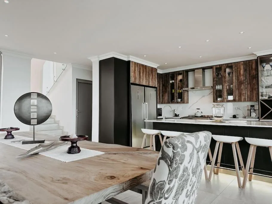 Modern kitchen with black cabinetry, stainless steel appliances, and dining counter seating