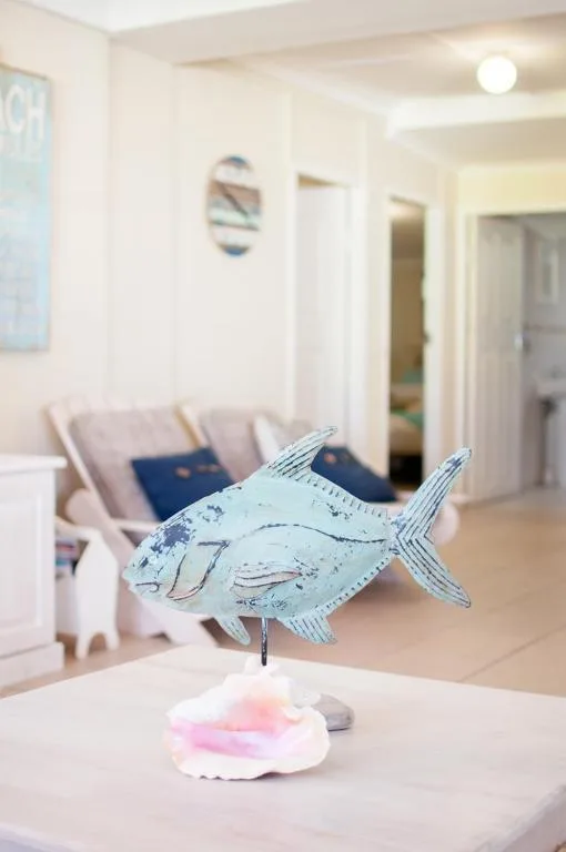 Decorative fish sculpture on white table in bright accommodation interior