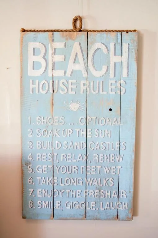 Beach house rules wooden sign with humorous vacation guidelines painted white