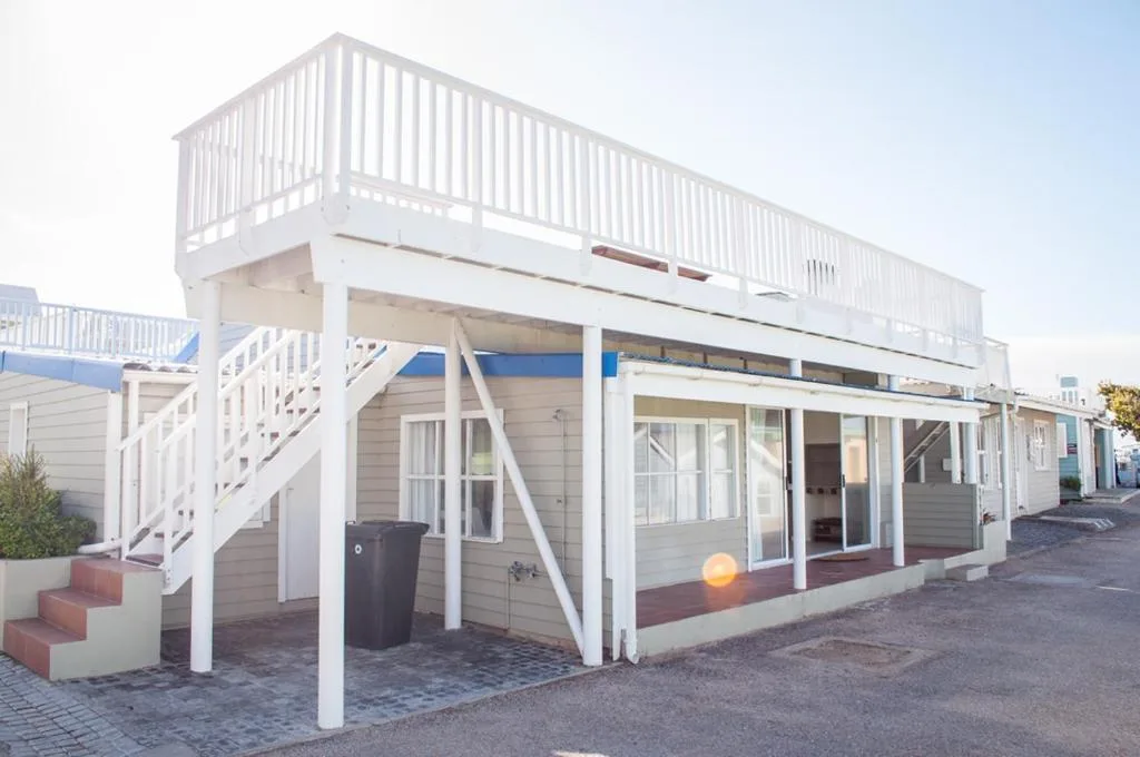 Modern white beach house with elevated deck and staircase entrance