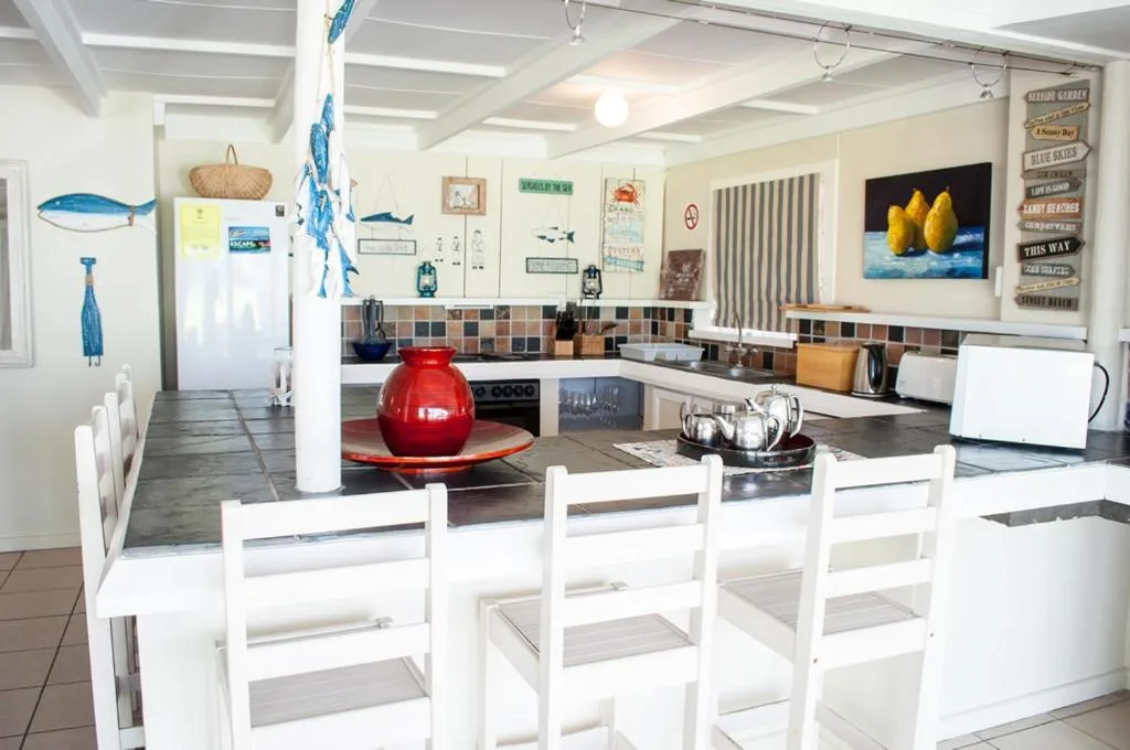 Bright open-plan kitchen with island seating, coastal decor, and modern appliances