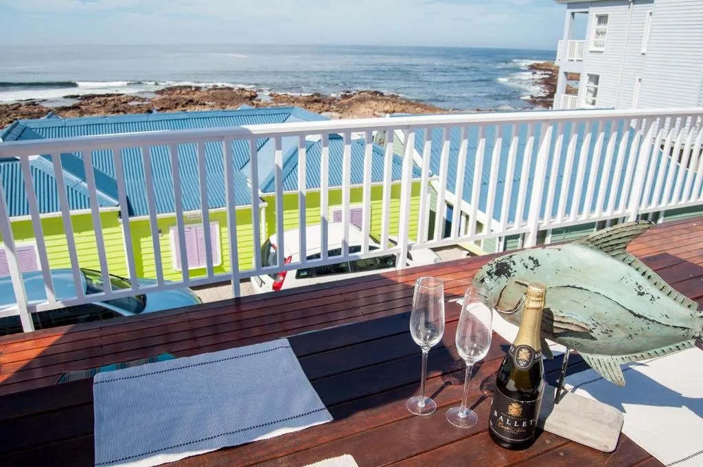 Ocean coastline with rocky shores visible from elevated beachfront deck
