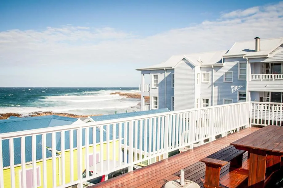 Oceanfront property with deck overlooking beach, pool, and turquoise sea
