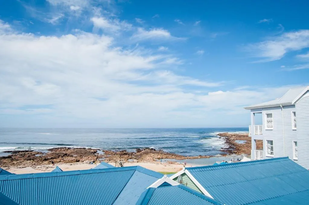Pristine ocean coastline with rocky shores and white building overlooking the sea