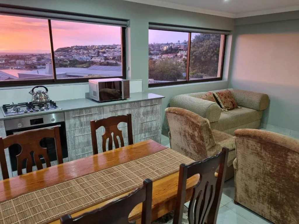 Open-plan lounge with dining area and expansive lagoon views through windows