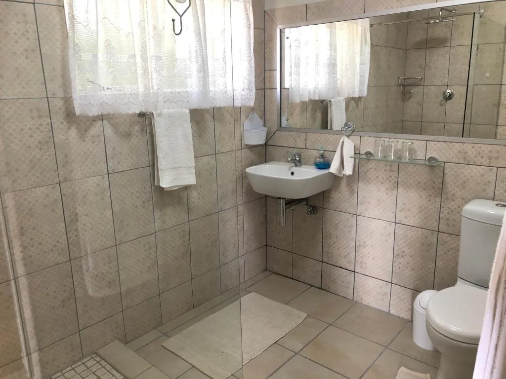 Modern bathroom with walk-in shower, vanity sink, and toilet fixtures