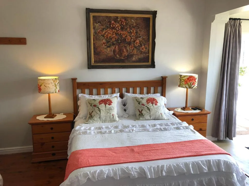 Spacious bedroom with wooden bed, floral pillows, and matching bedside tables