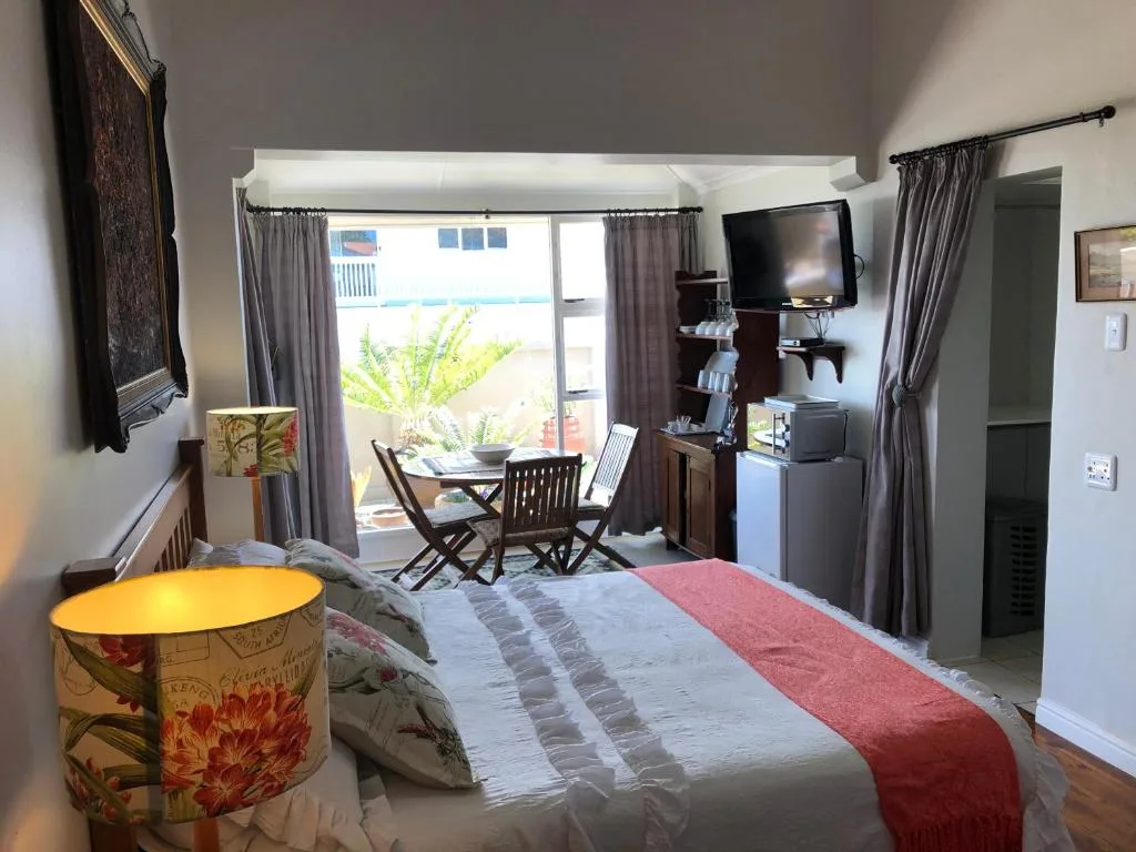 Spacious bedroom with bed, TV, and sliding doors to outdoor balcony area
