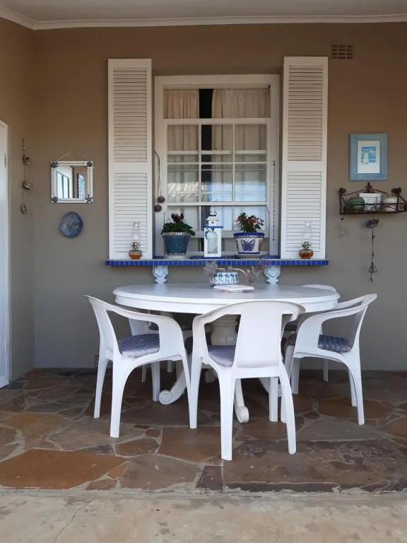 Bright dining area with white round table and chairs, coastal decor