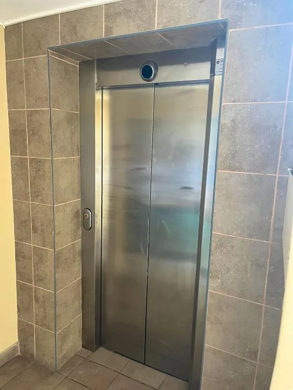 Modern shower enclosure with frosted glass doors and tiled walls