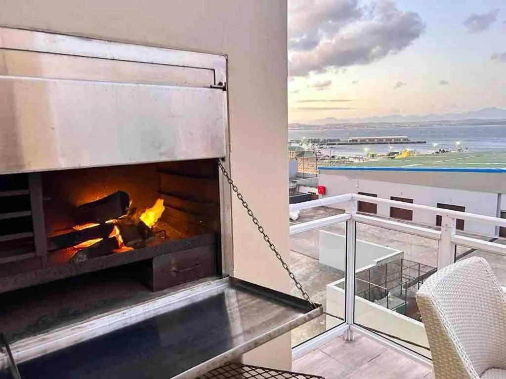 Outdoor deck with fireplace and lagoon view at sunset