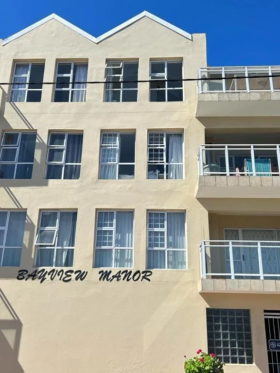 Cream-colored apartment building facade with multiple balconies and windows