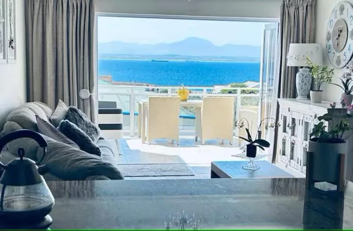 Bright lounge with ocean and mountain views through glass doors