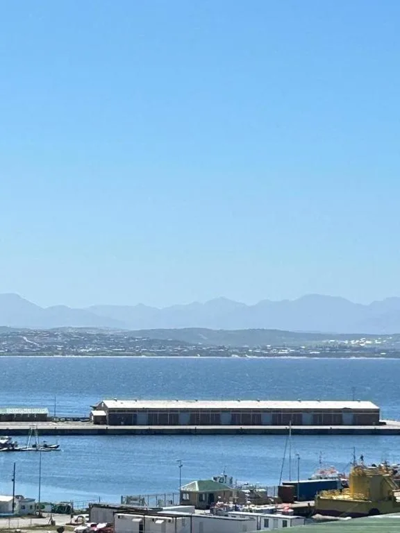 Scenic coastal view of Mossel Bay with mountains and waterfront buildings