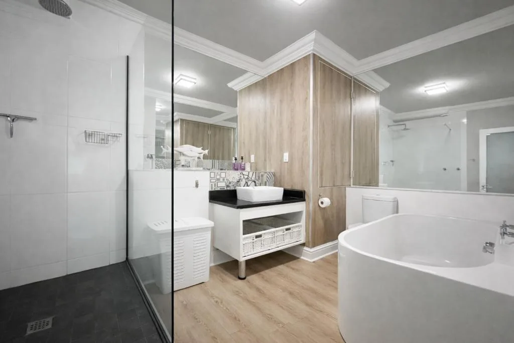 Modern bathroom with freestanding tub, walk-in shower, and dual vanity