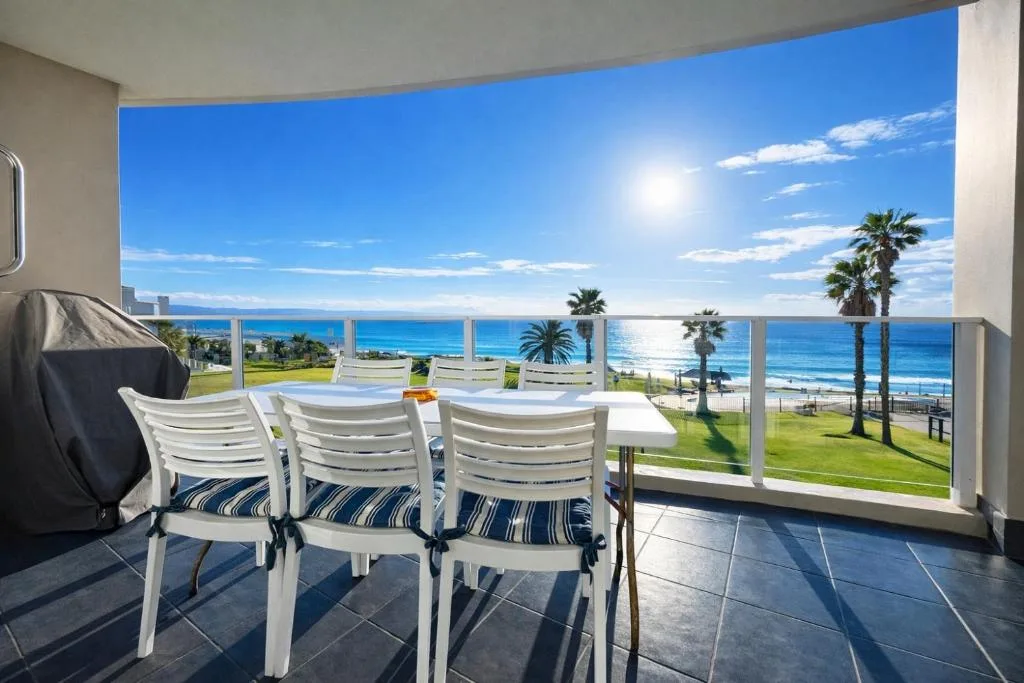 Ocean and beach view from spacious beachfront balcony with seating