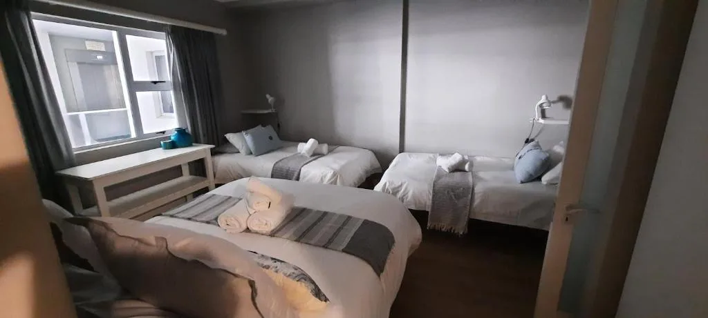 Spacious bedroom with multiple beds and natural window light