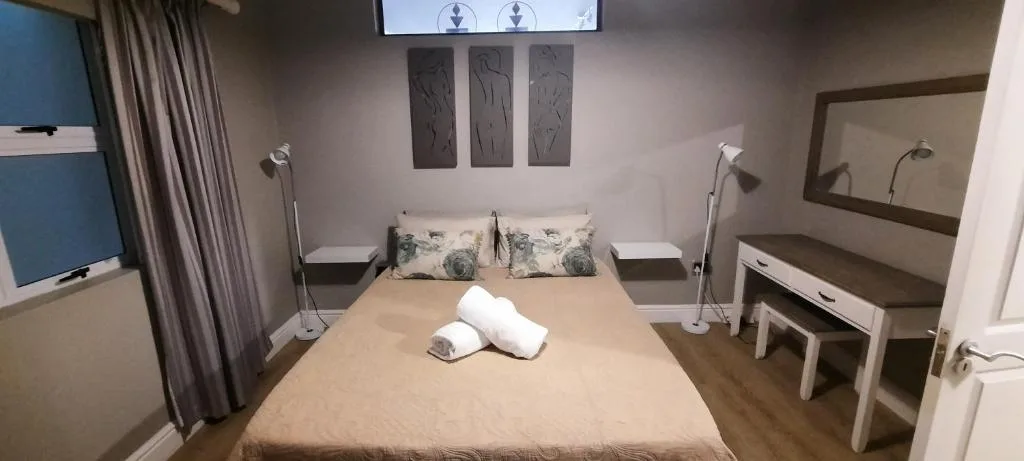 Modern bedroom with queen bed, rolled towels, and contemporary decor