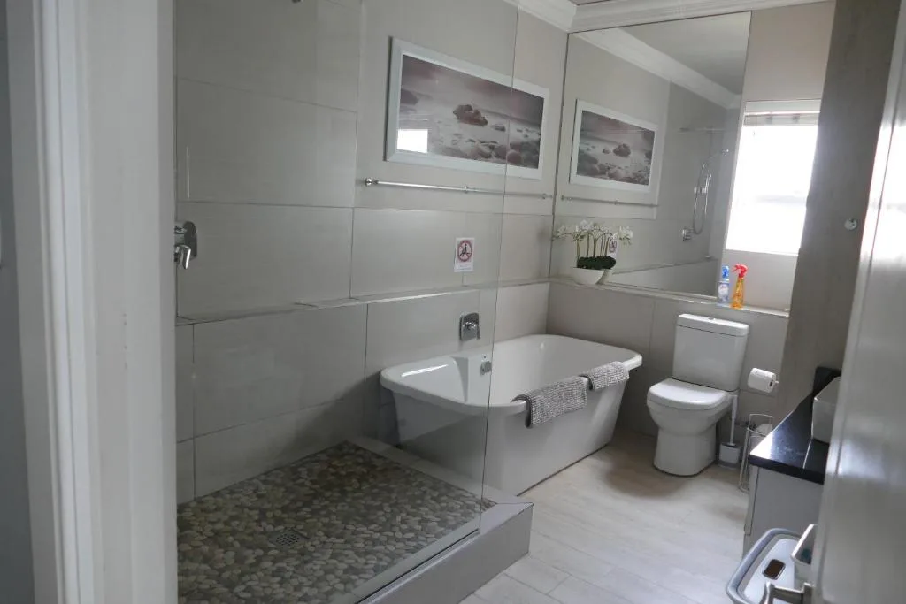 Modern bathroom with walk-in shower, freestanding tub, and toilet fixture