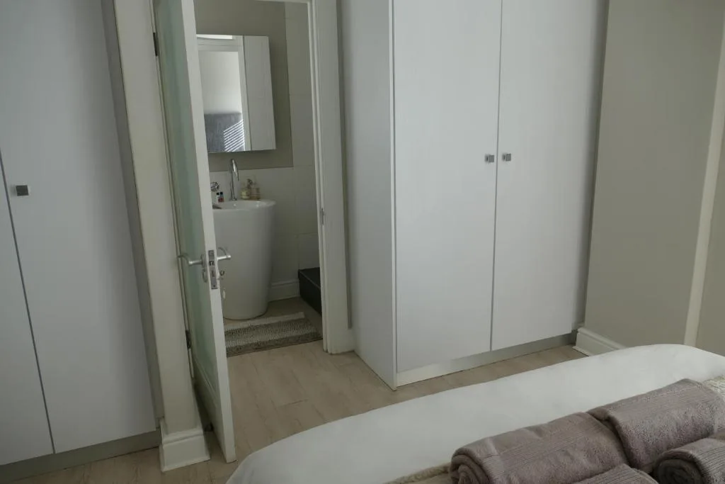 Modern bedroom with ensuite bathroom access and built-in wardrobe storage